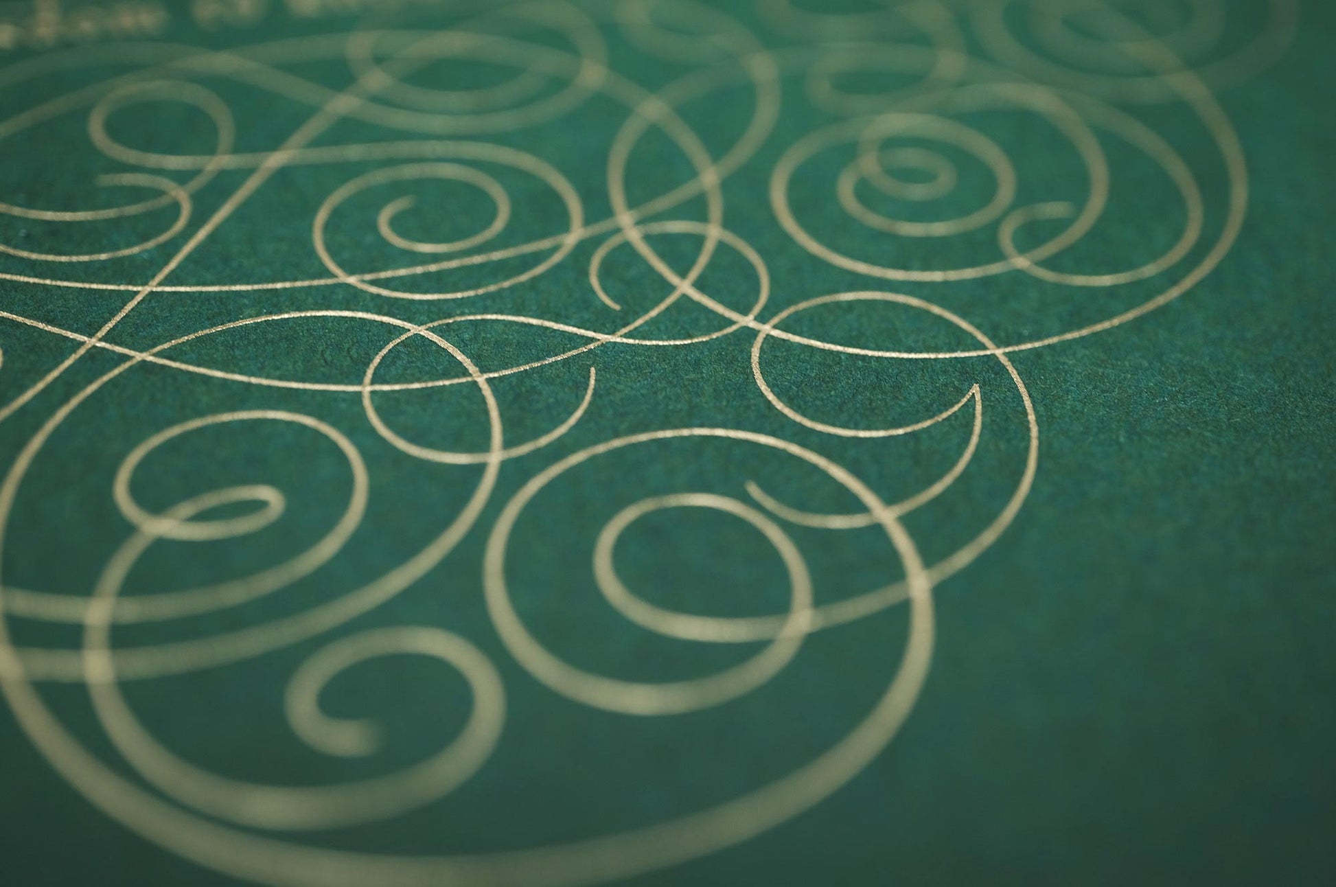 The serenity prayer die stamp print by Seb Lester in gold on green. Features text: "god grant me the serenity to accept the things I cannot change, courage to change the things I can and wisdom to know the different. Type in ornate font and flourishes and swirls around the text. Close up detail.