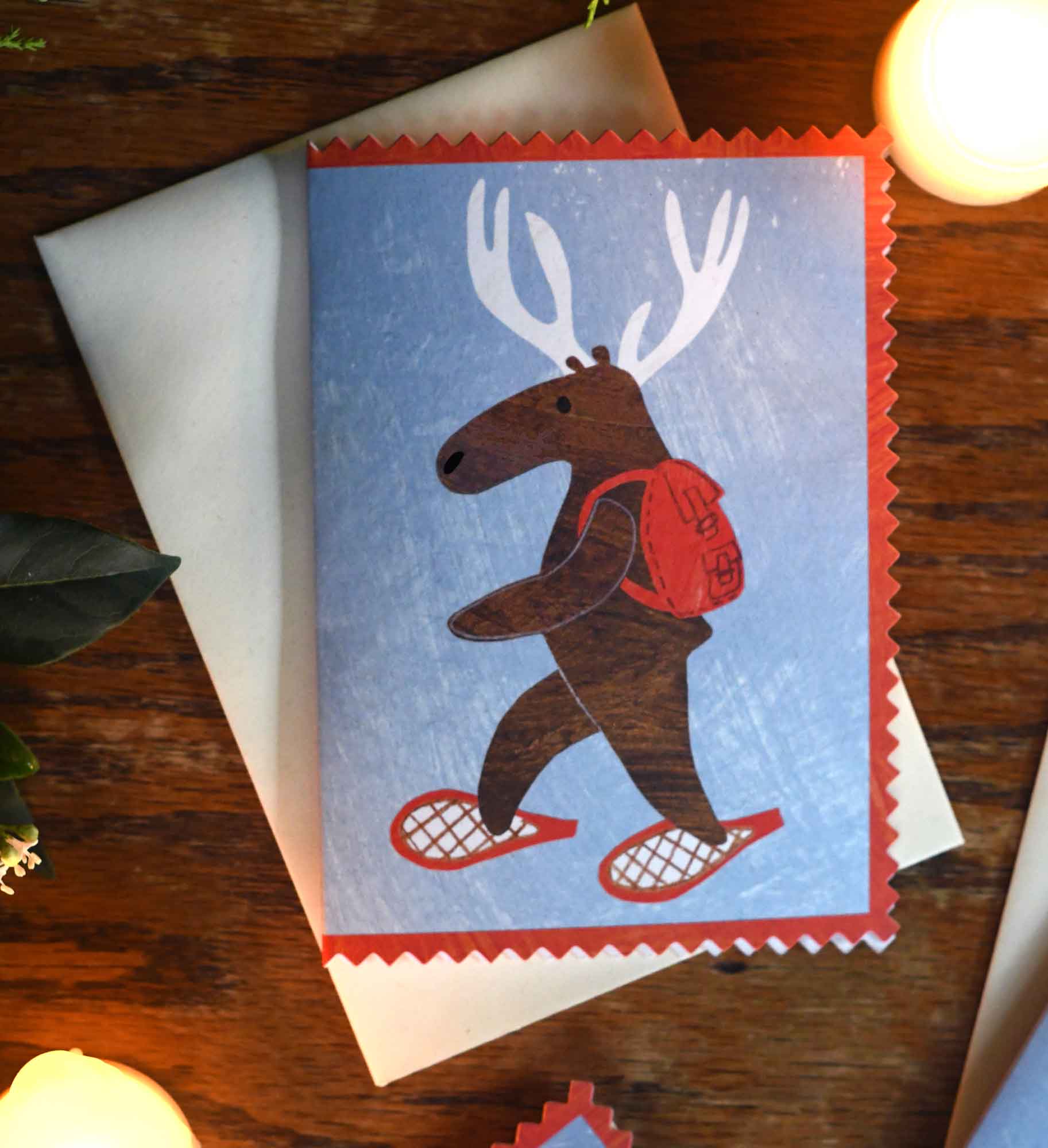 Moose or deer wearing snowshoes and a backpack christmas holiday greeting card by mortlake papers
