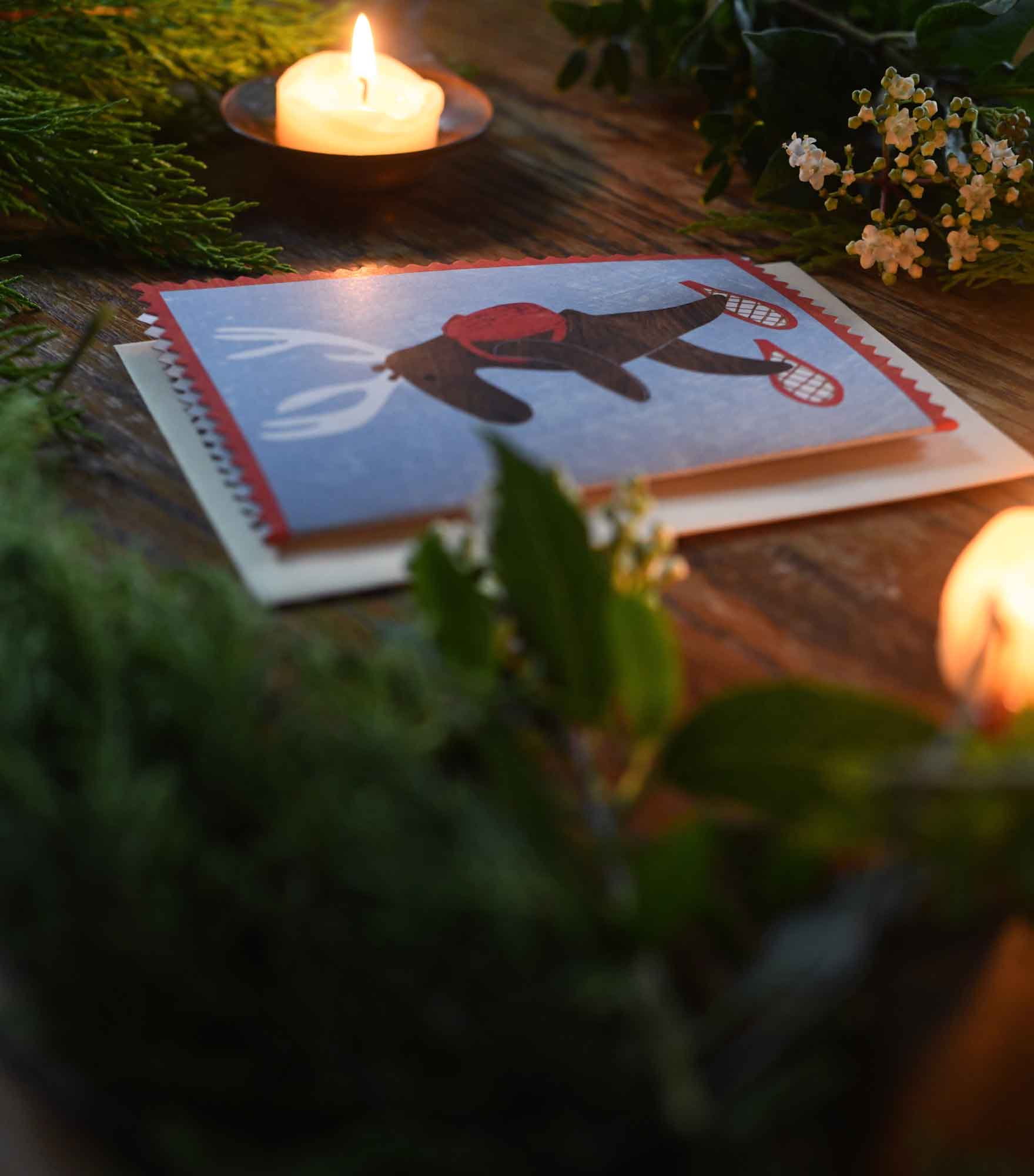 Moose or deer wearing snowshoes and a backpack christmas holiday greeting card by mortlake papers