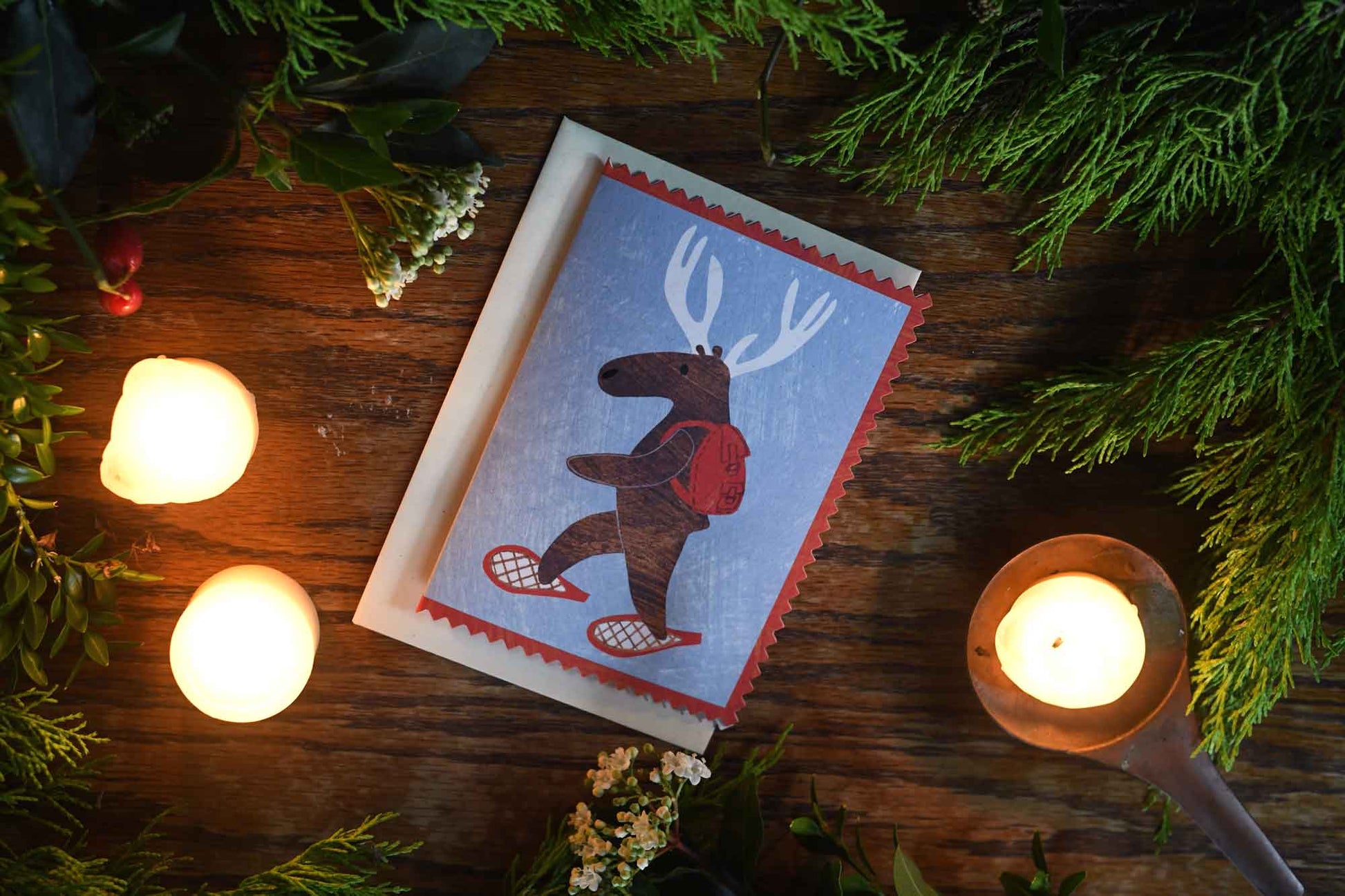 Moose or deer wearing snowshoes and a backpack christmas holiday greeting card by mortlake papers