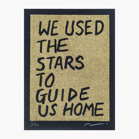 Gold glitter on black paper. Text reads: we used the stars to guide us home in handwritten capitals. By the artist Adam Bridgland and in his signature style.