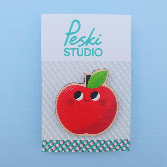 Red apple pin badge with smiley face
