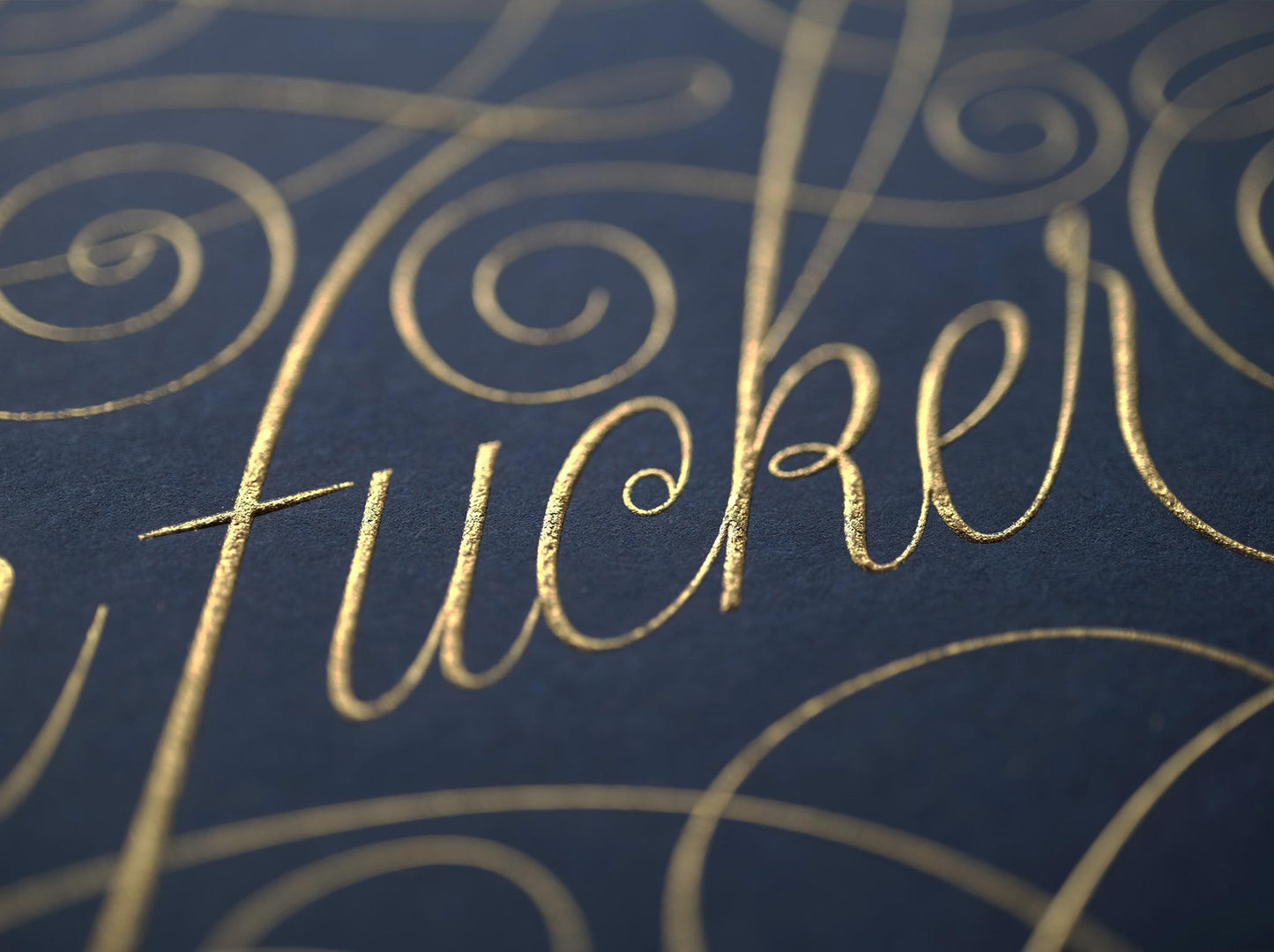 Cursive die stamped artwork by Seb lester. Featuring ornate swirls and swooshes around a swearword. Gold ink on blue paper.