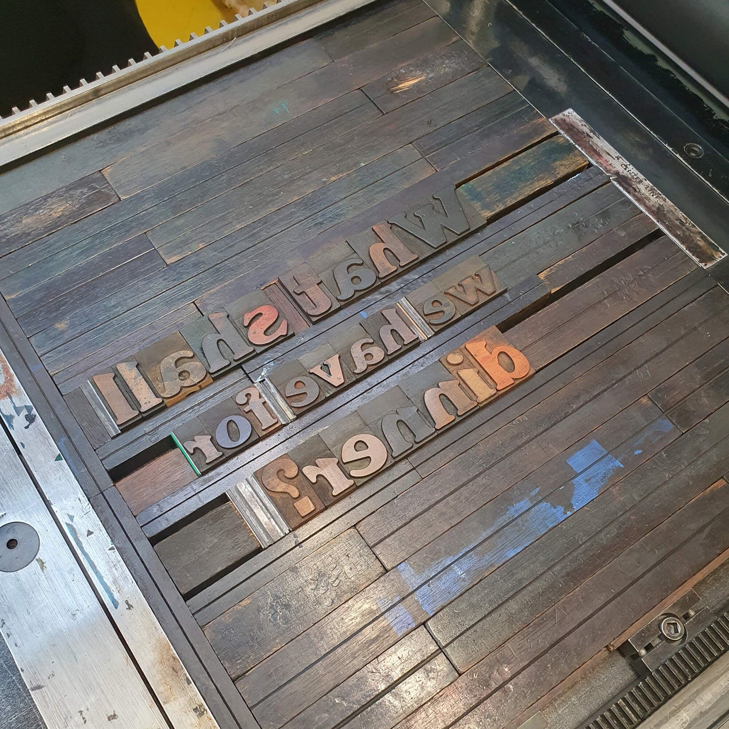 Dinner poster letterpress type in the letterpress lockup on the press.