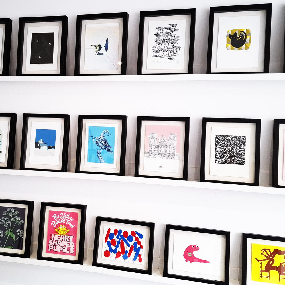 Shelves showing framed prints from Soma 20 years editions.