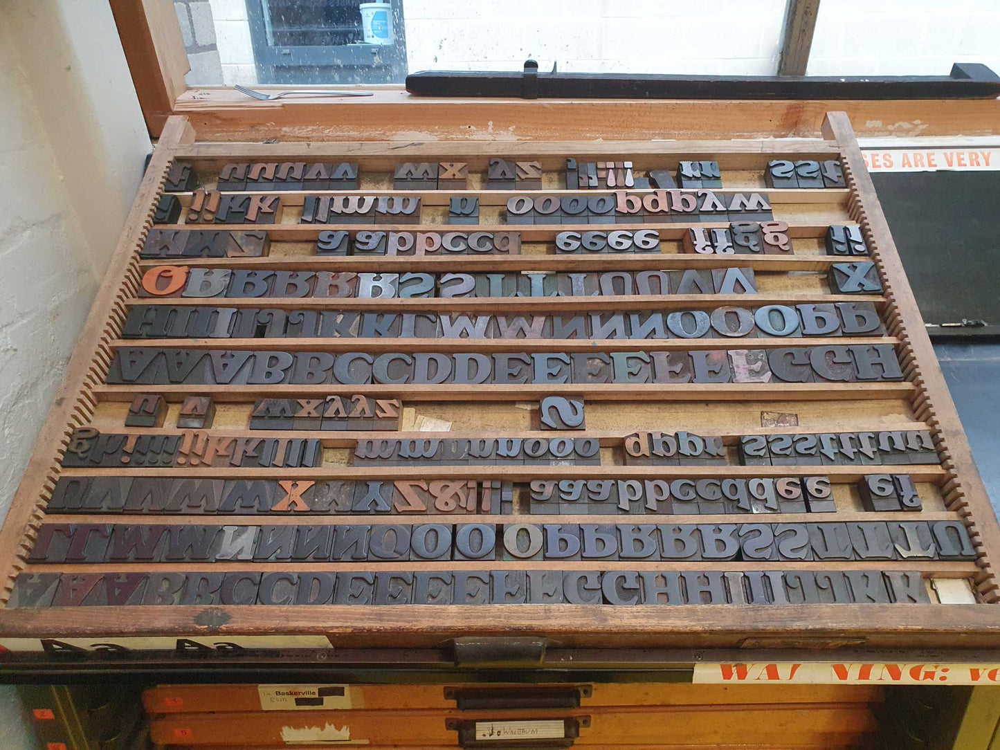 Tray of vintage wooden letterpress type that the Dinner poster was made with.