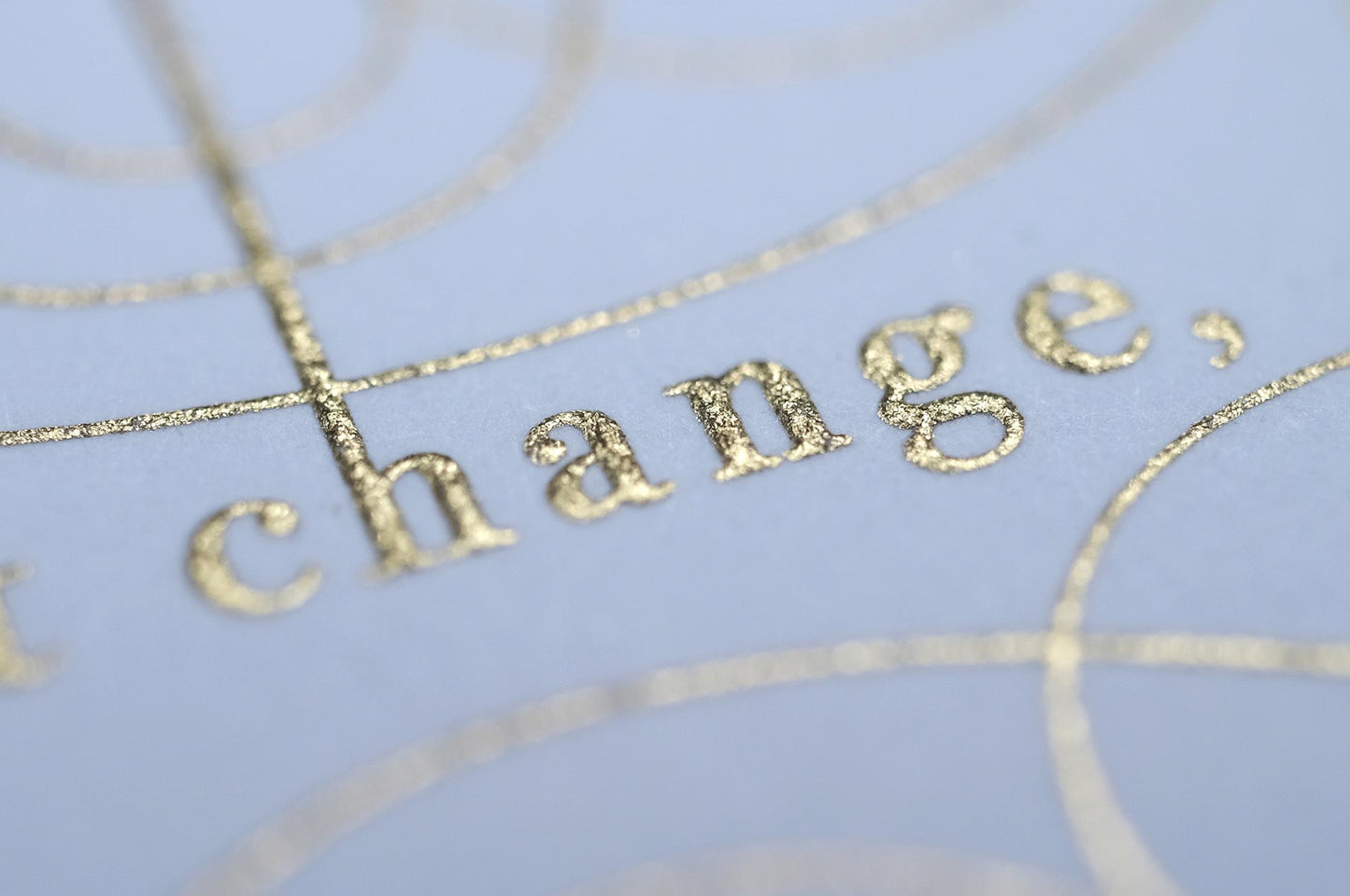 The serenity prayer die stamp print by Seb Lester in gold on white. Features text: "god grant me the serenity to accept the things I cannot change, courage to change the things I can and wisdom to know the different. Type in ornate font and flourishes and swirls around the text. Close up detail.