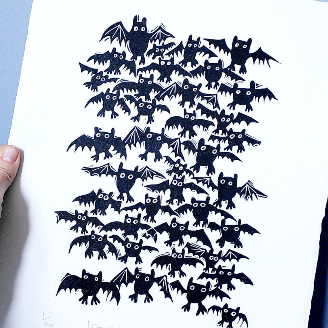 Artwork of black bat-shaped lino cuts on white paper by printmaker, Melanie Wickham.
