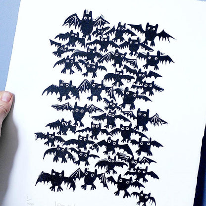 Artwork of black bat-shaped lino cuts on white paper by printmaker, Melanie Wickham.